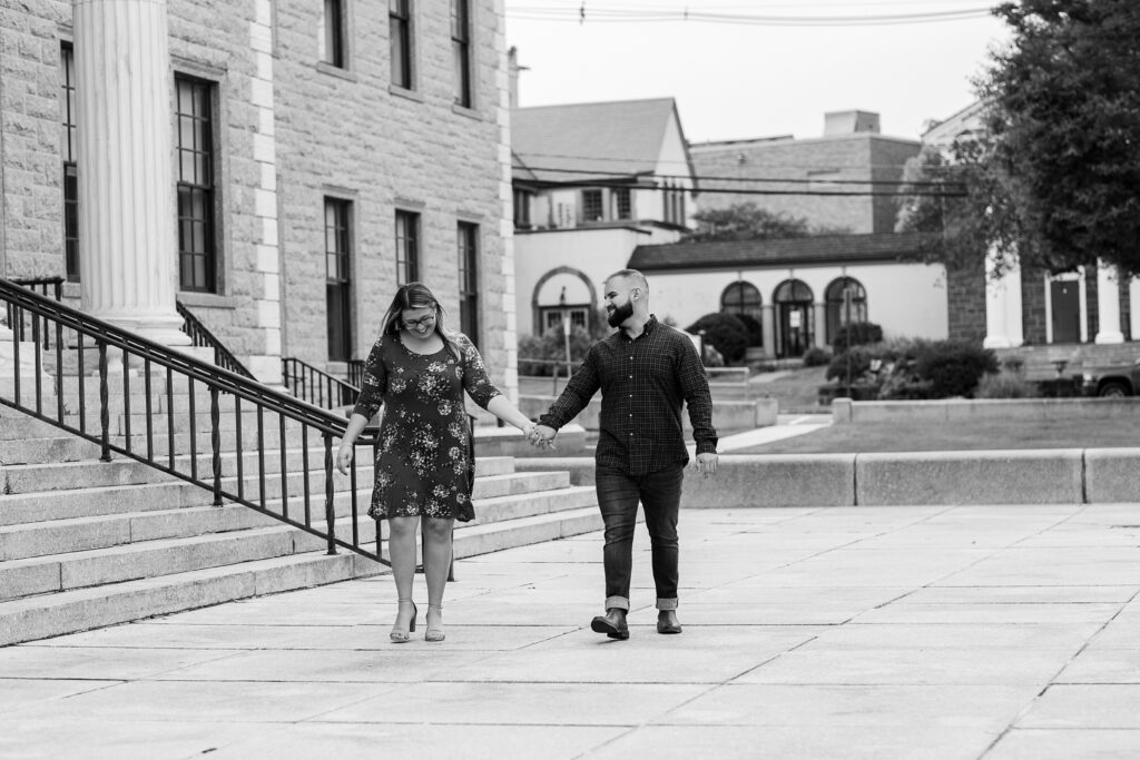 Black and white image of couple walking after proposal