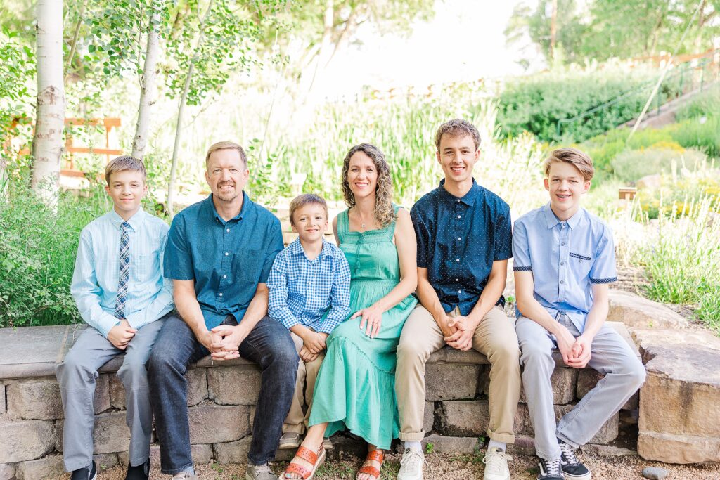 family of 6 sits on rock wall for photo 
Colorado Photographer 