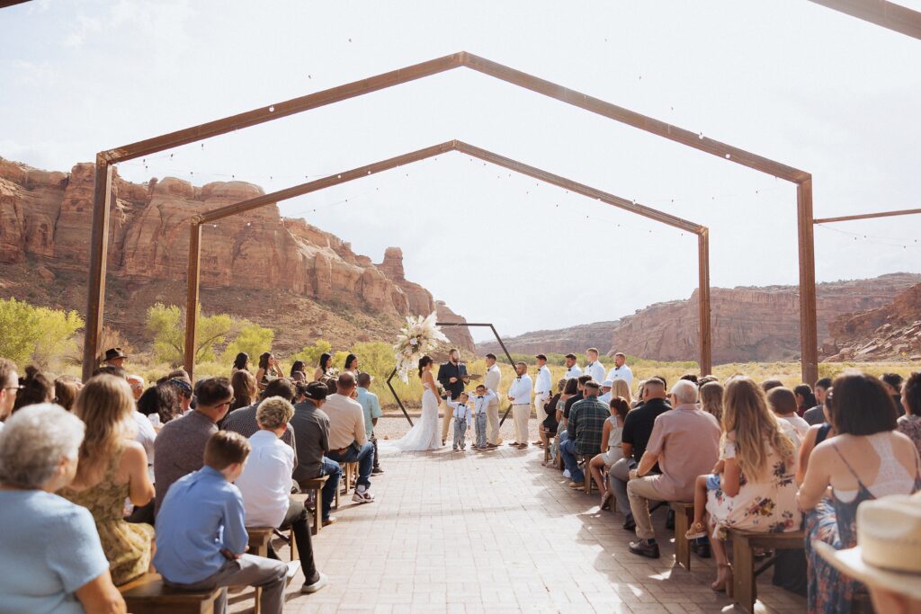 outdoor wedding ceremony at Red Earth Venue in Moab Utah
couple exchanging vows at Red Earth Venue Moab
Moab desert ceremony with guests and red rock backdrop